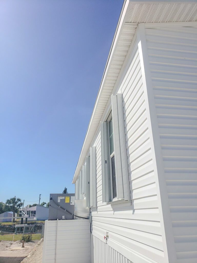 Exterior side view of a mobile home before metal carport and hurricane shutter installation project | Southwest Florida - Sun Control Aluminum & Remodeling